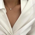 Close-up of minimalist silver chain necklace with a single lustrous white pearl pendant - Silver (X1683B)