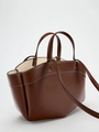Dettaglio della borsa tote in pelle marrone con cuciture bianche e manici robusti - Castano