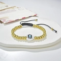 Detail of beaded evil eye bracelet with golden beads and white heart on a stone stand - White Heart