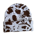 Close-up of the cow print pattern and thick knit texture on the warm winter beanie - Cow Print - White & Light Brown