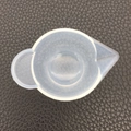 Close-up of a 100ml silicone measuring cup with scale and spout on a dark textured background - Unpackaged Color Mixing Cup 60-291