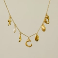 Dettaglio della collana in oro 18k con ciondoli a forma di stella marina, perla e lettera C - Lettera C