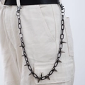 Detail van punkstijl gunmetal broekketting met metalen spikes op witte broek - X500-3 Pistool Zwart