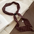 Nahaufnahme der roten karierten Chiffon-Halskette mit schwarzer Perle auf Buch - Halskette-Dunkelrot