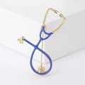 Close-up of a gold stethoscope brooch with blue enamel detail on a white background - Blue