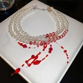 Detailed shot of multi-layer necklace featuring white pearls and red beaded tassels - Multi-layer Tassel Pearl Necklace / White-Red