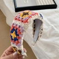Handmade colorful crochet headband featuring multi-color floral embroidery held in hand - White Colorful Crochet Embroidered Headband