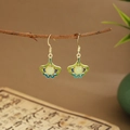 Detailed shot of green fan-shaped leaf earrings with tassels hanging on a branch - Ginkgo Leaf Shape (E6453)