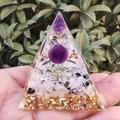 Orgone energy pyramid with amethyst sphere and gold foil held against green plants - Purple Ball Moonstone / Small