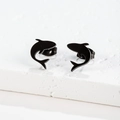 Macro shot of minimalist matte black shark stud earrings on a textured stone surface - Dolphin / Black