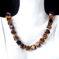 Faceted tiger eye natural stone necklace on white mannequin with black background - Tiger's Eye