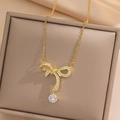Elegante collar de lazo dorado con colgante de circón sobre fondo de tela suave - Dorado (403)