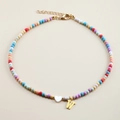 Detailed view of colorful beaded necklace with white heart and gold letter W pendant - Letter W