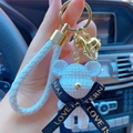 White cartoon resin bear keychain with woven strap and gold bell shown in car interior - Full Set (With Woven Rope + Bell) / White