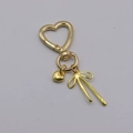 Golden heart-shaped keychain with heart and bow pendants in polished metal finish - Gold Heart Buckle