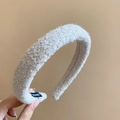 Close-up of beige bouclé fabric headband featuring a handmade label and soft texture - Off-white