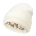 Detail of warm cream knit beanie showing the smooth protective satin lining texture - White