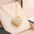 Macro view of gold heart pendant with zircon stones in a premium jewelry gift box - Gold