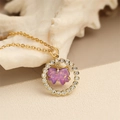 Dettaglio ravvicinato di una collana dorata con ciondolo a farfalla in cristallo viola e diamanti - Fiocco Viola Rotondo / Viola