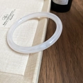Detalle del brazalete de resina translúcida blanca con textura de mármol en bandeja - Brazalete Redondo Traslúcido / Brazalete-Color Plata