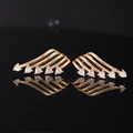 Exquisite gold angel wing earrings featuring heart-shaped crystals on mirror background - Clear