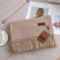 Elegant camel beige cashmere-feel scarf with fringe details on a cozy gray sofa - Light Camel