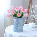 Pink PU tulips in light blue ceramic vase with text on a bright minimalist table - Deep Pink