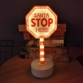 Insegna LED Santa Stop Here con asta a strisce rosse e bianche e base stabile - Cartello stradale ottagonale / Alimentato a batteria