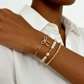 Three-piece gold chain bracelet set with bow pendant and pearls on model wrist - Gold (2791)