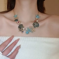 Detail of gold necklace featuring enamel starfish, green shells, and pearls on a model - Luxury Multicolor Enamel Starfish Shell (10#)