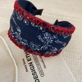 Close-up of wide floral knot headband with red hand-crocheted edges and pearls - Navy Blue Floral Print Headband