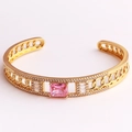 Macro shot of gold chain-link bracelet with center pink square stone and white pavé gems - Pink Zirconia