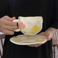 Detail of handmade ceramic coffee cup and saucer set with hand-painted tulips pattern - Pink Yellow Tulip