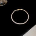 Detailed close-up of golden tennis bracelet with rectangular-cut zircons on black velvet - 1# Bracelet - Gold