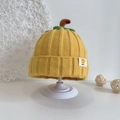 Detailansicht der gelben Kürbis-Strickmütze für Babys mit grünem Blatt und braunem Stiel - Gelb
