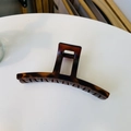 Macro detail of large tortoiseshell claw clip with amber texture on a white surface - Matte Red Brown