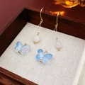 Detail of gold drop earrings featuring white beads and translucent blue butterflies - Blue Butterfly Style (Ear hook-Blue-Butterfly)