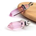Pink hexagonal crystal point pendant with silver metal clasp on wooden coaster - Transparent Pink