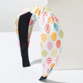 Detail of Easter knotted headband featuring colorful hand-drawn egg patterns on white fabric - White Pink