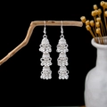 Ethnic style silver tiered tassel bell earrings hanging on a branch in a dark artistic setting - Three-layer Bell Tassel Style (E5884)