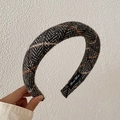 Thick knitted headband in dark gray herringbone pattern with a Hand Made label - Black Herringbone Plaid