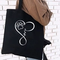 Black canvas tote bag featuring white love heart and paw print graphic design - Love Infinity Print