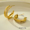 Macro detail of 18K gold geometric earrings with striped texture and cubic zirconia inlay - 18K Gold / Gold