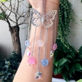 Detail view of a silver butterfly suncatcher with colorful floral crystal pendants and chains - Silver Butterfly Rose Star