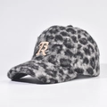 Dettaglio del tessuto spesso in lana d'agnello leopardata e lettera R dorata sul cappello - Grigio / Regolabile