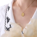 Elegant gold oval pendant necklace with floral engraving shown on a female model - August Flower(P1147) / 40cm+5cm / Gold