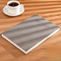 Gray B5 faux leather business notebook with embossed text on a rustic wooden desk - Ruled / B5-Grey