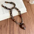 Dettaglio collana bohémien in tessuto leopardato con cuore in legno e ciondolo orb - 15# Collana-Caffè