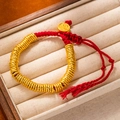 Macro shot of red braided rope bracelet with gold textured beads and Fu charm pendant - L269-2 Gold Buckle