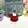 Détail du monstre en peluche rouge avec lunettes et bonnet tricoté sur un sac en jean - Rouge